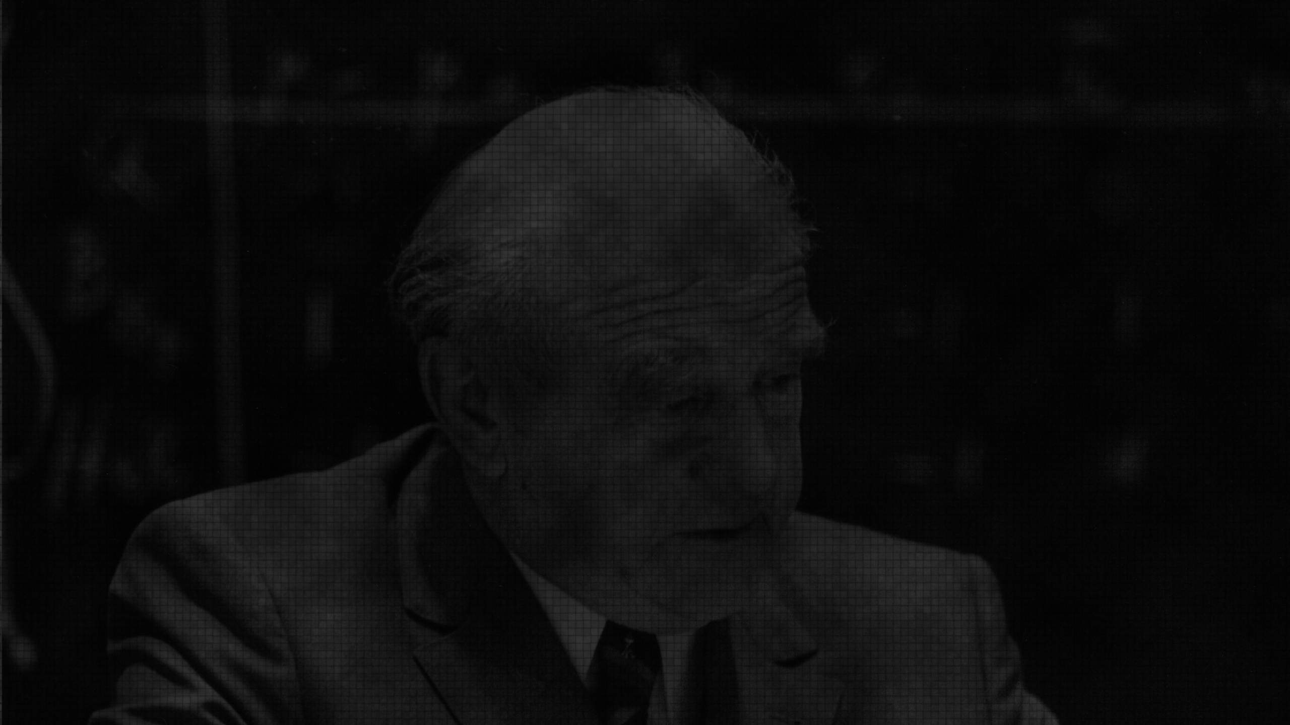 Werner Heisenberg lecturing in front of a blackboard with mathmatical equations.