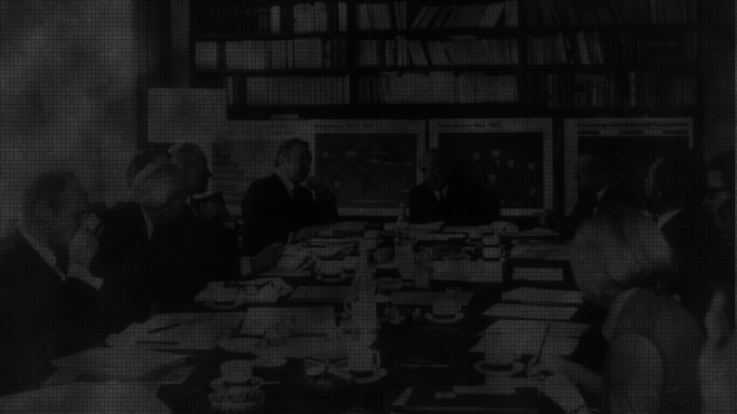 Werner Heisenberg lecturing in front of a blackboard with mathmatical equations.